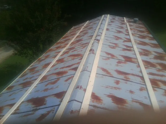 Rusted metal roof panels with new wood purlins before replacement — Storm Damage Roof Repair in Puryear by Roofing Brothers